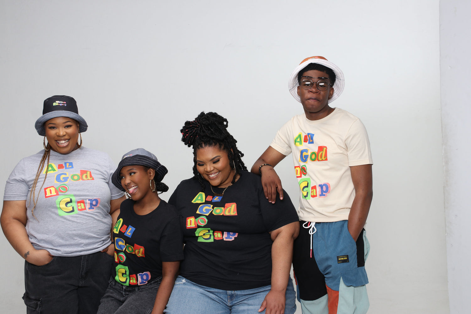 The photo features a group of people wearing T-shirts with matching designs. They are standing close together, smiling, and looking happy. The T-shirts are the same style and color, with a bold design on the front that is visible in the image. The group appears to be diverse, with a mix of different genders, ages, and ethnicities. They seem to be enjoying each other's company and showcasing the T-shirts as a cohesive and stylish team.